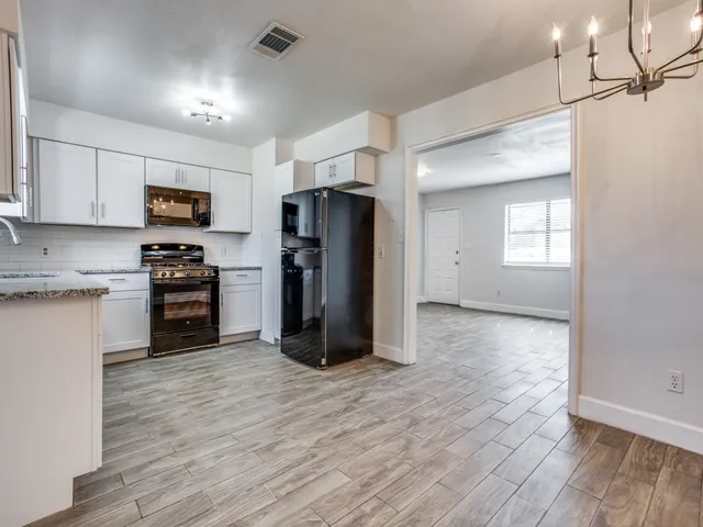a kitchen with a refrigerator and a stove top oven