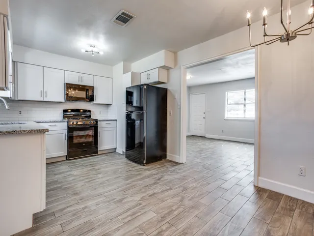 a kitchen with a refrigerator and a stove top oven