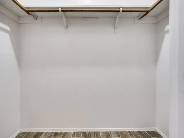 a view of walk in closet with empty racks