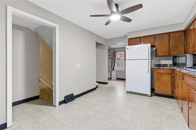 a view of kitchen with refrigerator cabinets and ceiling fan