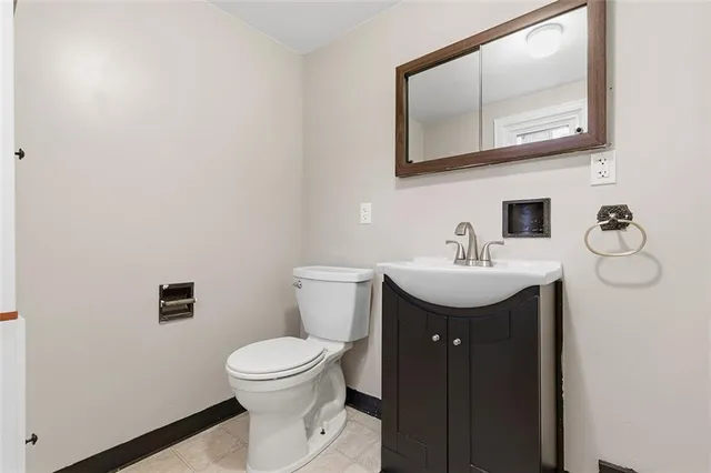 a bathroom with a toilet a sink and mirror