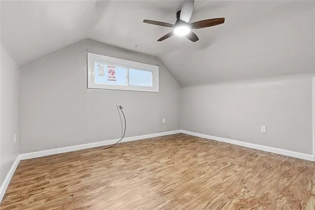 a view of a room with wooden floor and a ceiling fan