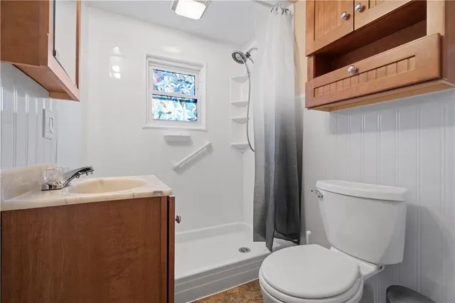 a bathroom with a sink a toilet and shower
