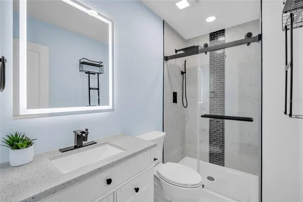 a bathroom with a granite countertop sink toilet and shower