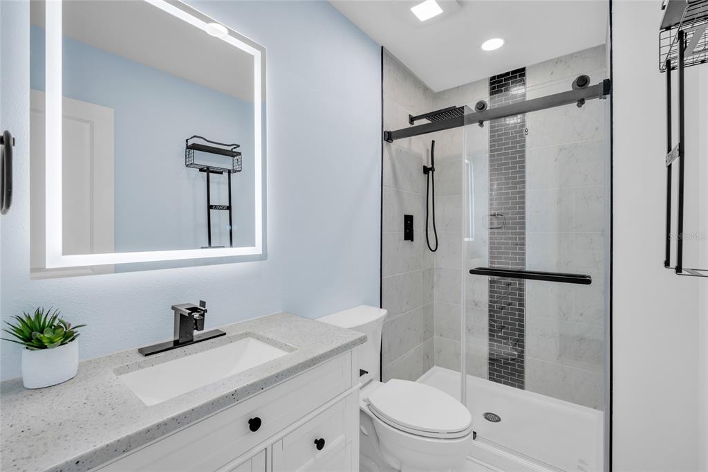 445 63rd Street Holmes Beach, FL 34217 - Photo 22 of 45 a bathroom with a granite countertop sink toilet and shower