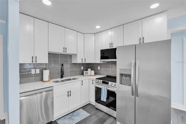 a kitchen with cabinets stainless steel appliances and sink