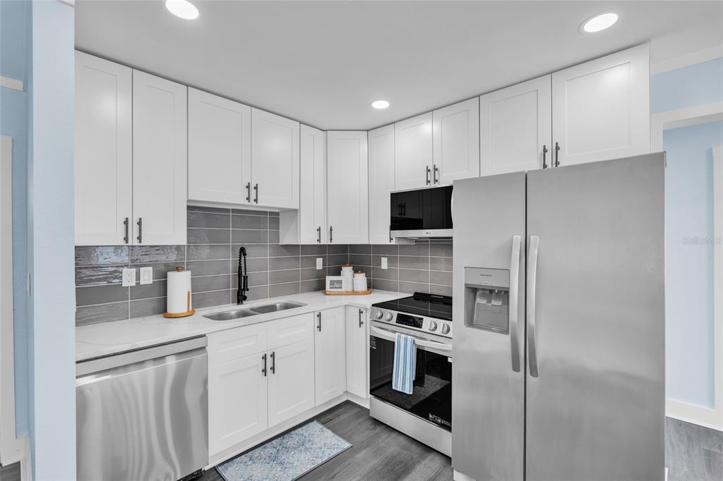 445 63rd Street Holmes Beach, FL 34217 - Photo 3 of 45 a kitchen with cabinets stainless steel appliances and sink