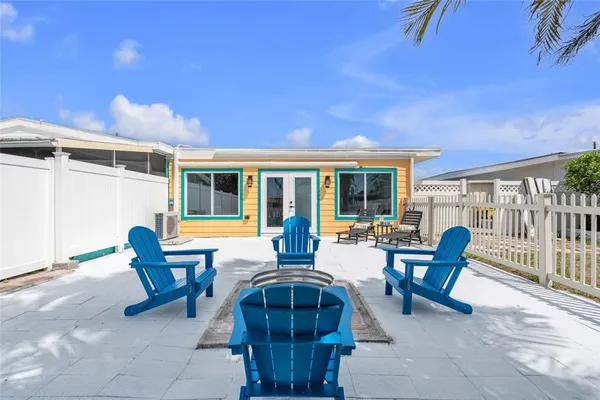 a view of a patio with table and chairs and wooden fence