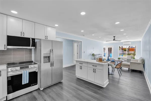 a kitchen with stainless steel appliances kitchen island granite countertop a stove and a refrigerator