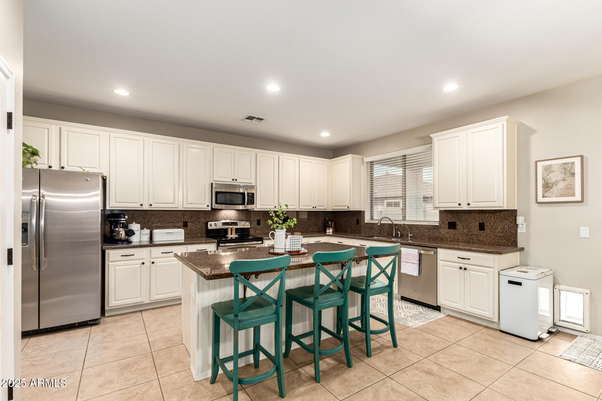 3721 South Martingale Road Gilbert, AZ 85297 - Photo 23 of 67 a kitchen with stainless steel appliances kitchen island granite countertop a table chairs sink and cabinets