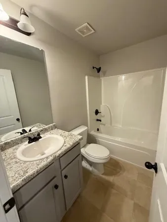 a bathroom with a granite countertop sink toilet a mirror and shower