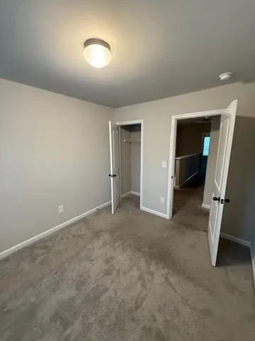 an empty room with furniture and a ceiling fan