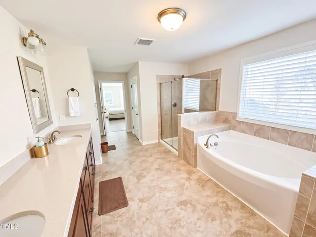 a bathroom with a tub sink and mirror