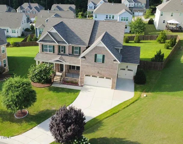an aerial view of a house with swimming pool and a yard