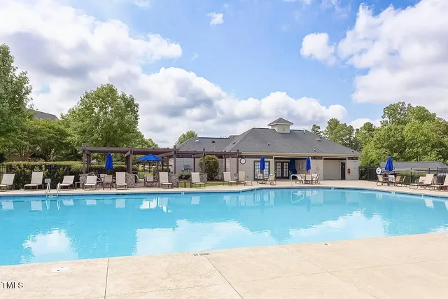 a view of a house with pool and chairs