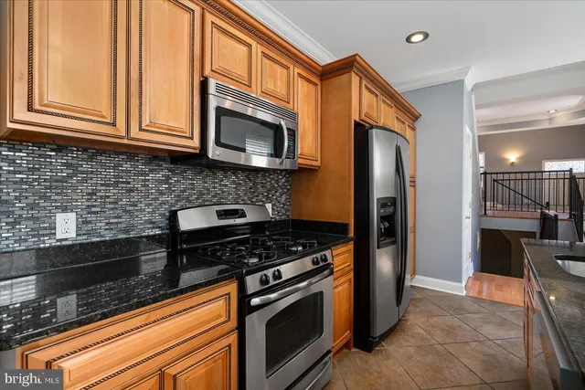 a kitchen with stainless steel appliances granite countertop a stove microwave and refrigerator