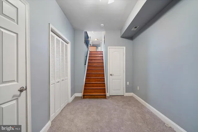 a view of a hallway with stairs and a white door