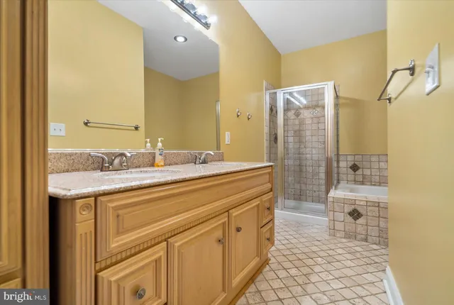 a spacious bathroom with a granite countertop sink a toilet and a shower