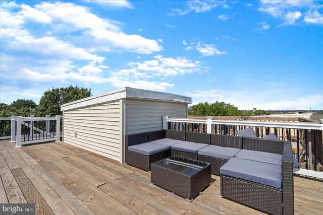 a view of a roof deck with couches and sky view