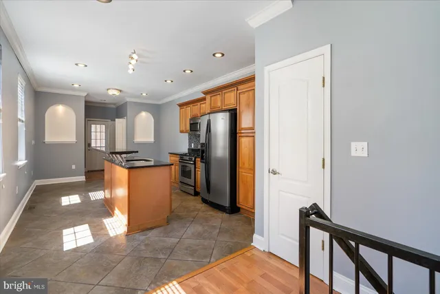 a dining hall with stainless steel appliances granite countertop a refrigerator and a stove
