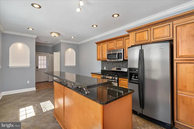 a kitchen with stainless steel appliances granite countertop a refrigerator a sink a stove and island