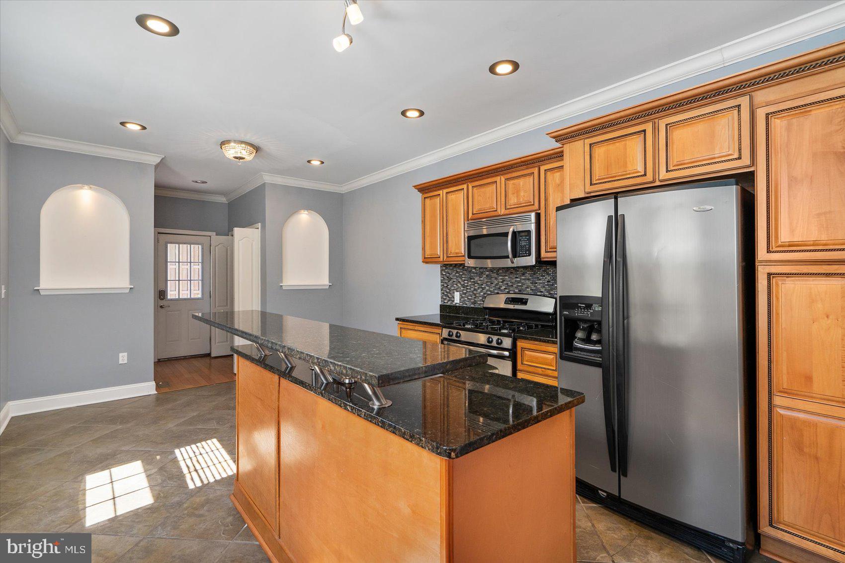104 North Patterson Park Avenue Baltimore, MD 21231 - Photo 10 of 38 a kitchen with stainless steel appliances granite countertop a refrigerator a sink a stove and island