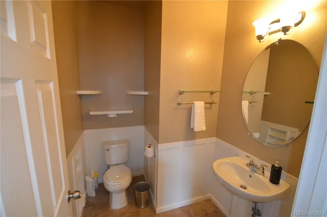 a bathroom with a toilet sink and mirror