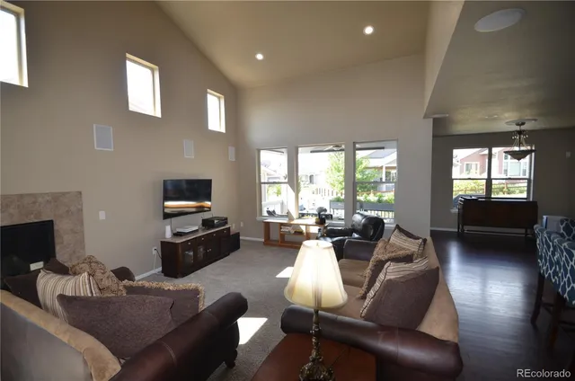 a living room with furniture a flat screen tv and a large window