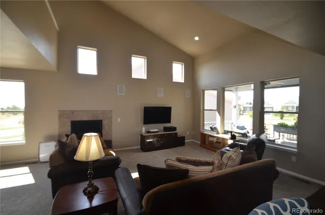 a living room with furniture flat screen tv and a large window