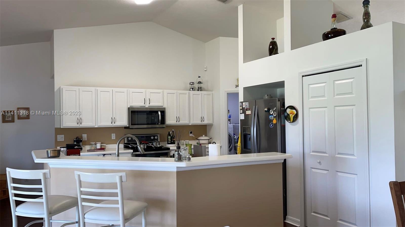 4292 Southwest Paley Road Port St. Lucie, FL 34953 - Photo 9 of 21 a kitchen with a refrigerator and a stove top oven