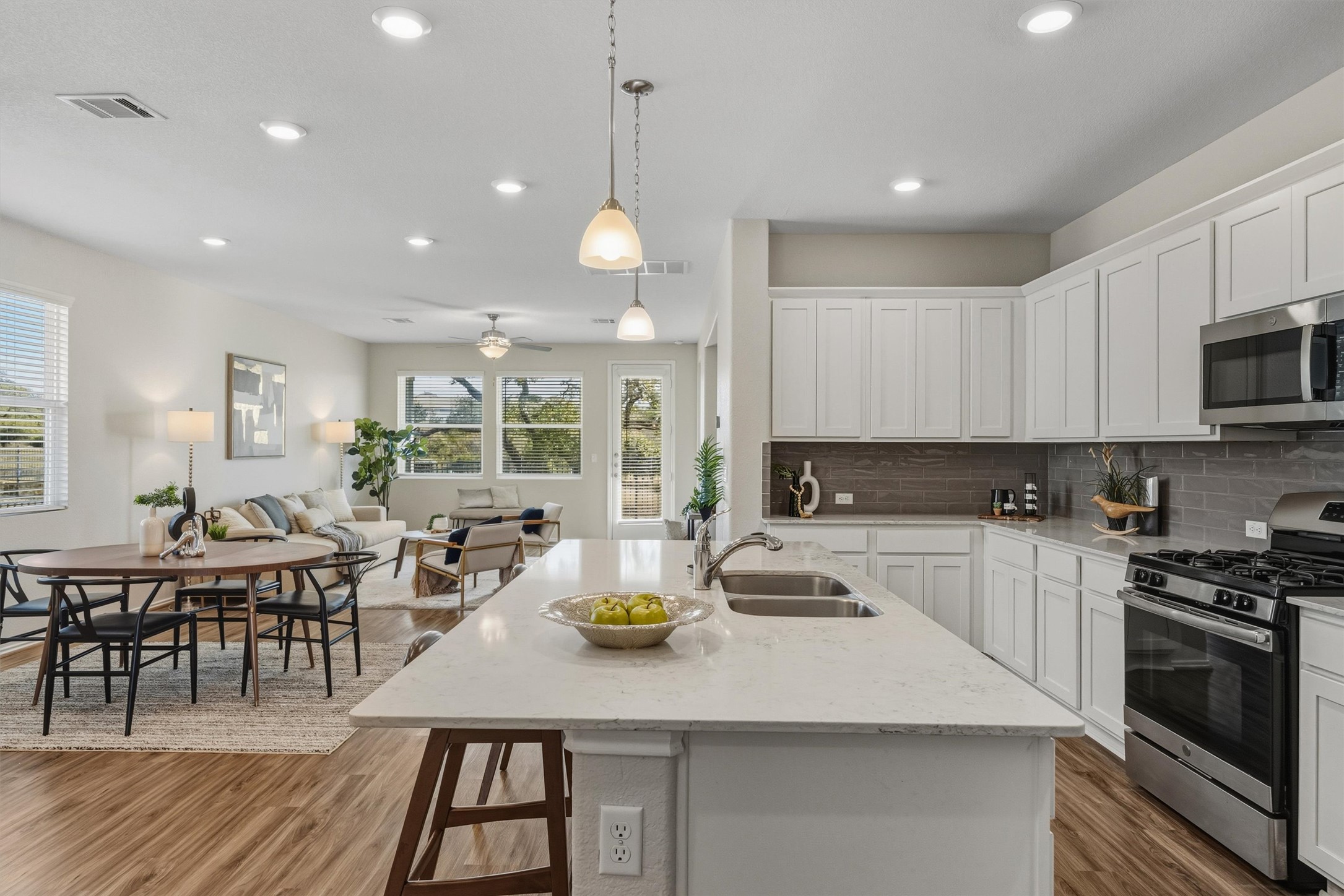 316 Montauk Loop Georgetown, TX 78628 - Photo 1 of 1 Kitchen featuring stainless steel appliances, white cabinets, quartz counters, hanging light fixtures, and open floor plan