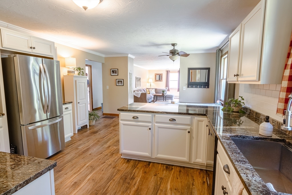 27 Comins Road North Oxford, MA 01537 - Photo 8 of 32 a kitchen with stainless steel appliances granite countertop a refrigerator a sink dishwasher a stove and white countertops with wooden floor