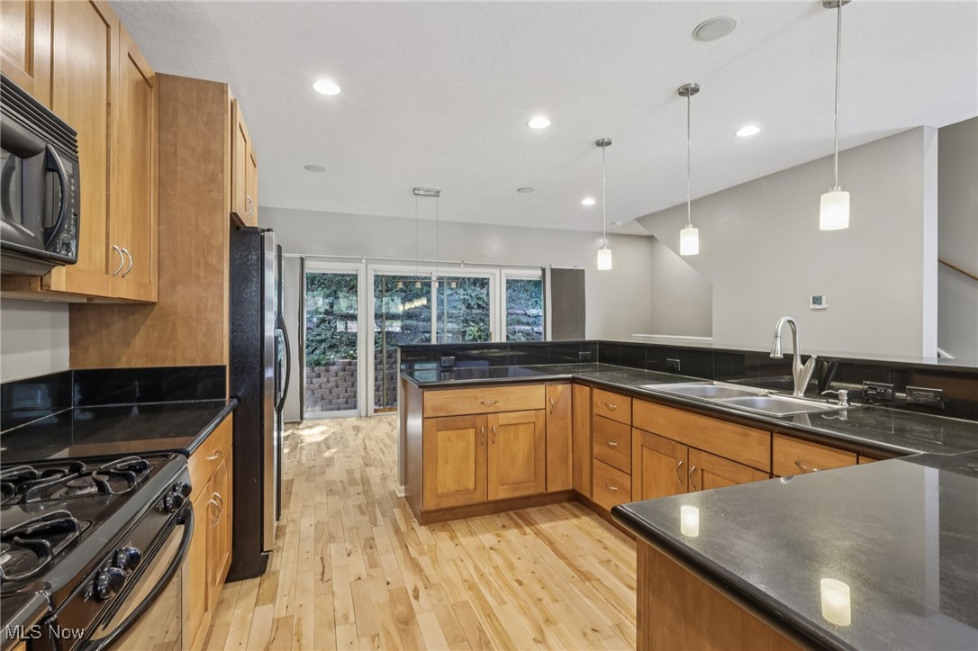 1951 Columbus Road Cleveland, OH 44113 - Photo 9 of 46 Kitchen with wood cabinetry, wood-style floors, recessed lighting, and stainless steel appliances