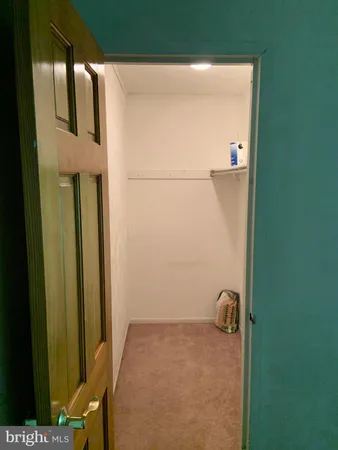 an empty room with wooden floor mirror and closet