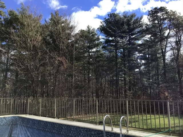 a view of backyard with wooden fence and trees