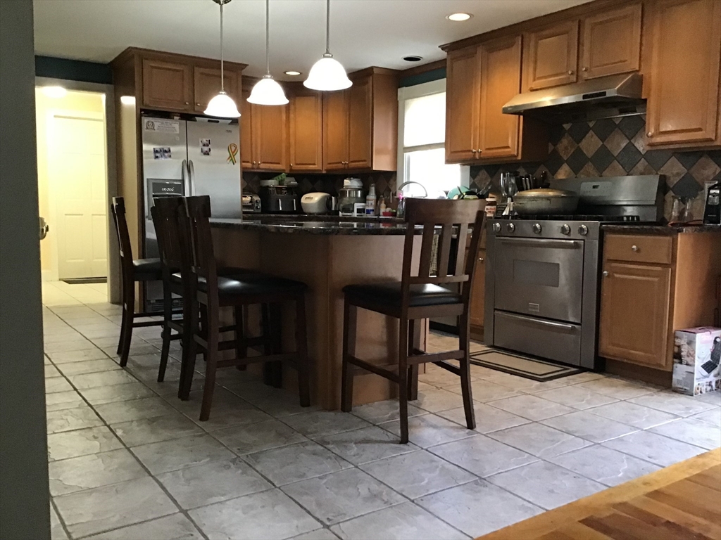 299 Three Rivers Road Wilbraham, MA 01095 - Photo 20 of 32 a kitchen with stainless steel appliances granite countertop a stove a sink a microwave and a refrigerator