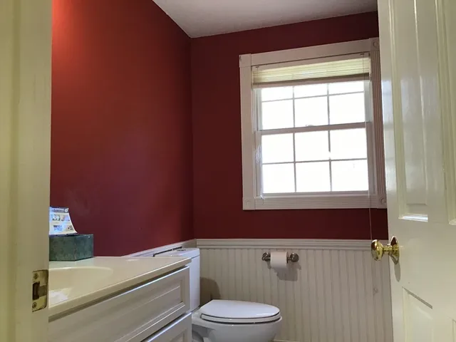 a bathroom with a toilet a sink and a window