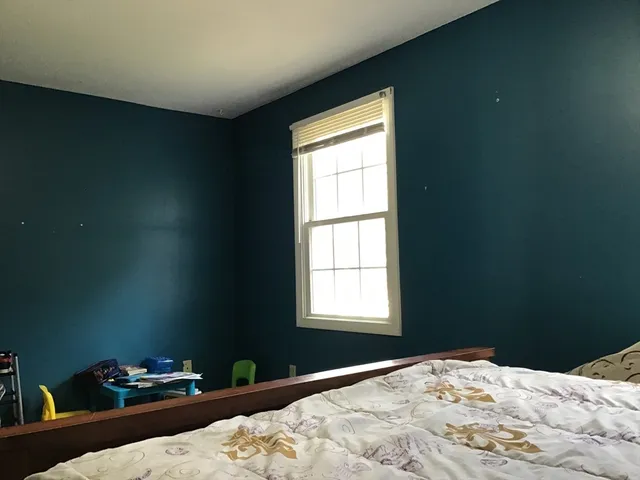 a bedroom with a bed and a window