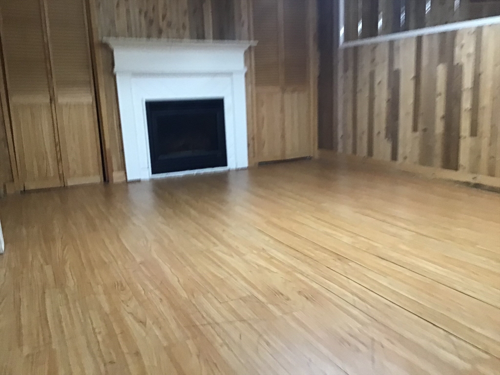 299 Three Rivers Road Wilbraham, MA 01095 - Photo 32 of 32 a view of an empty room with wooden floor and a fireplace