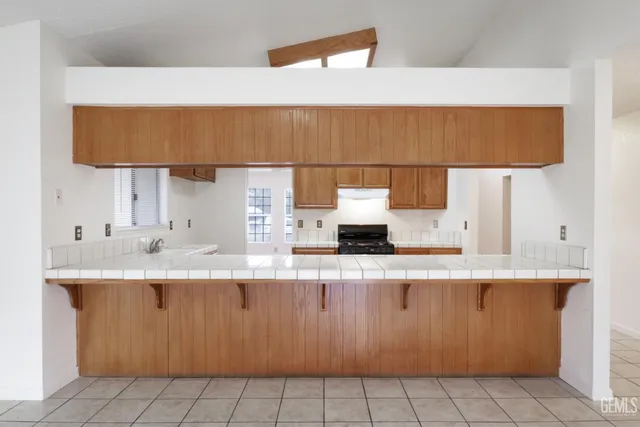 a kitchen with kitchen island a sink a stove and a refrigerator