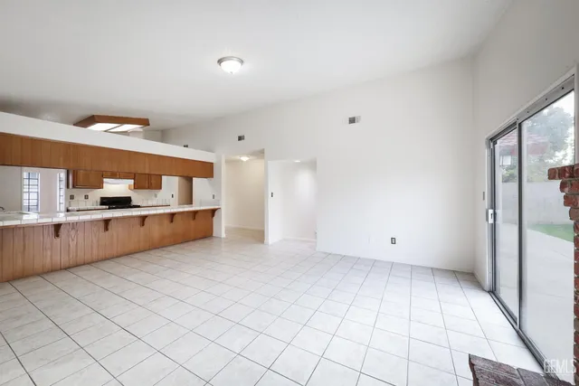 a view of kitchen with refrigerator cabinets and window