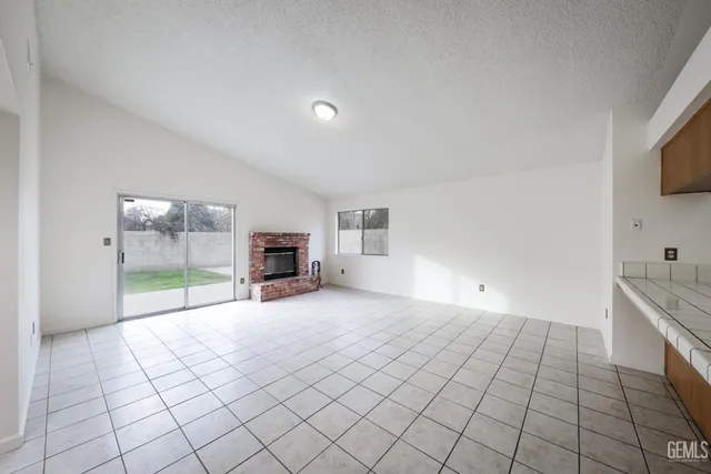 a view of empty room with wooden floor and fireplace