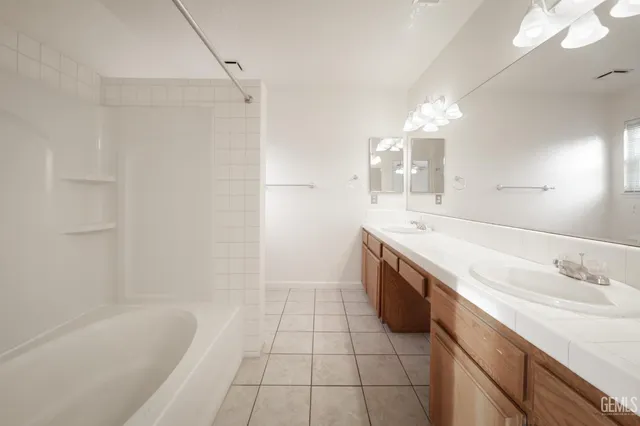 a spacious bathroom with a granite countertop sink a toilet a mirror and bathtub