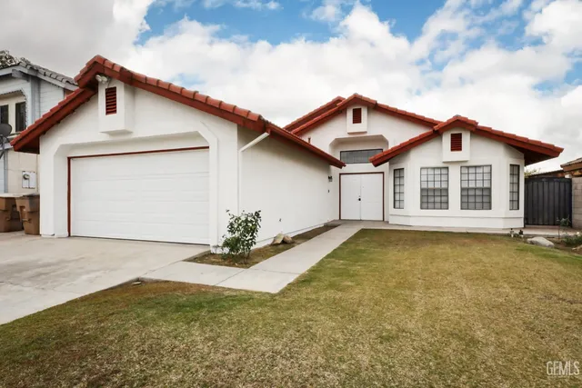 a view of a house with a yard and garage
