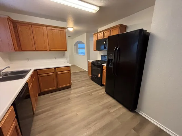 a kitchen with stainless steel appliances granite countertop a refrigerator and a sink