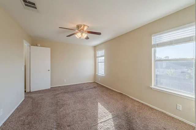 a view of room with a ceiling fan and window