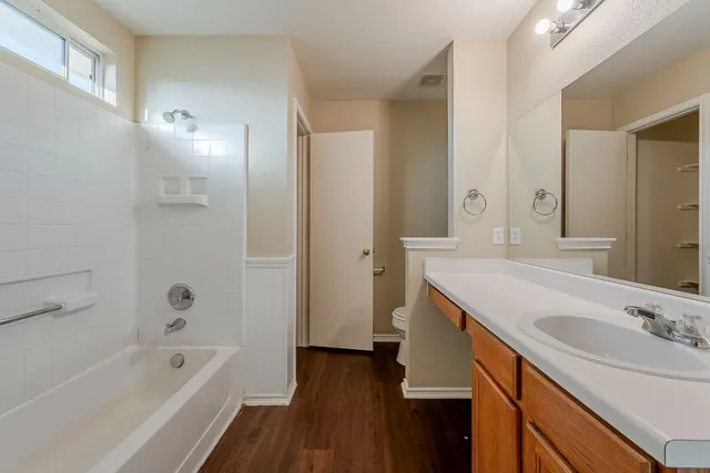 a bathroom with a tub sink double vanity granite tub shower and mirror