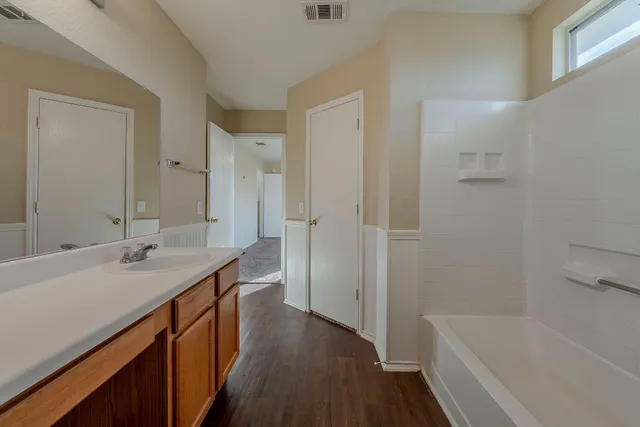 a bathroom with a tub sink and mirror