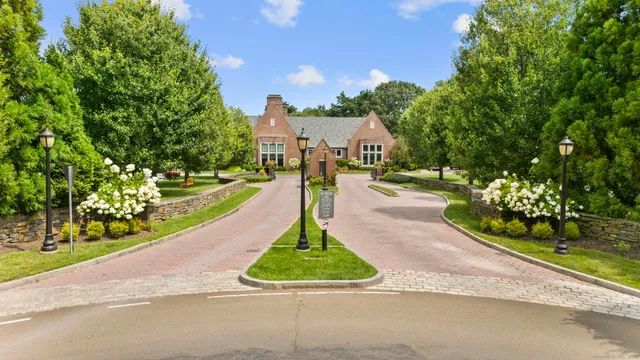 a front view of a house with a yard and green space
