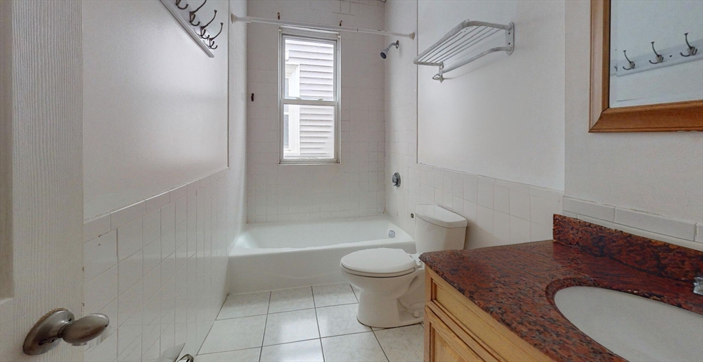19 Newport Street, Unit 2 Boston, MA 02125 - Photo 12 of 13 a bathroom with a granite countertop toilet sink and mirror